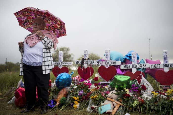 Katy Novak helps to lead dozens of people standing in the rain in prayer and song at the memorial crosses near the Sutherland Springs First Baptist Church one week after 26 people were killed.