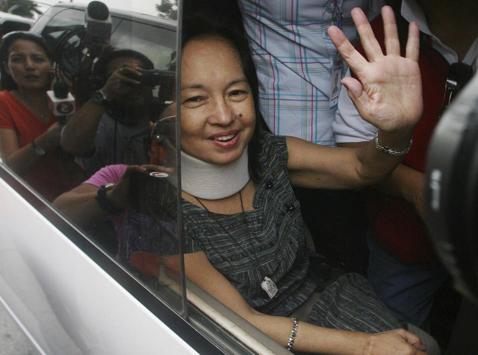 Former Philippine President Gloria Macapagal Arroyo waves to her supporters as she arrives at her village in suburban Quezon City, north of Manila, Philippines, Wednesday July 25, 2012. Arroyo on Wednesday walked out of a government hospital where she has been detained for nearly eight months on charges of election sabotage after a court found that evidence against her was weak and granted bail. (AP Photo)