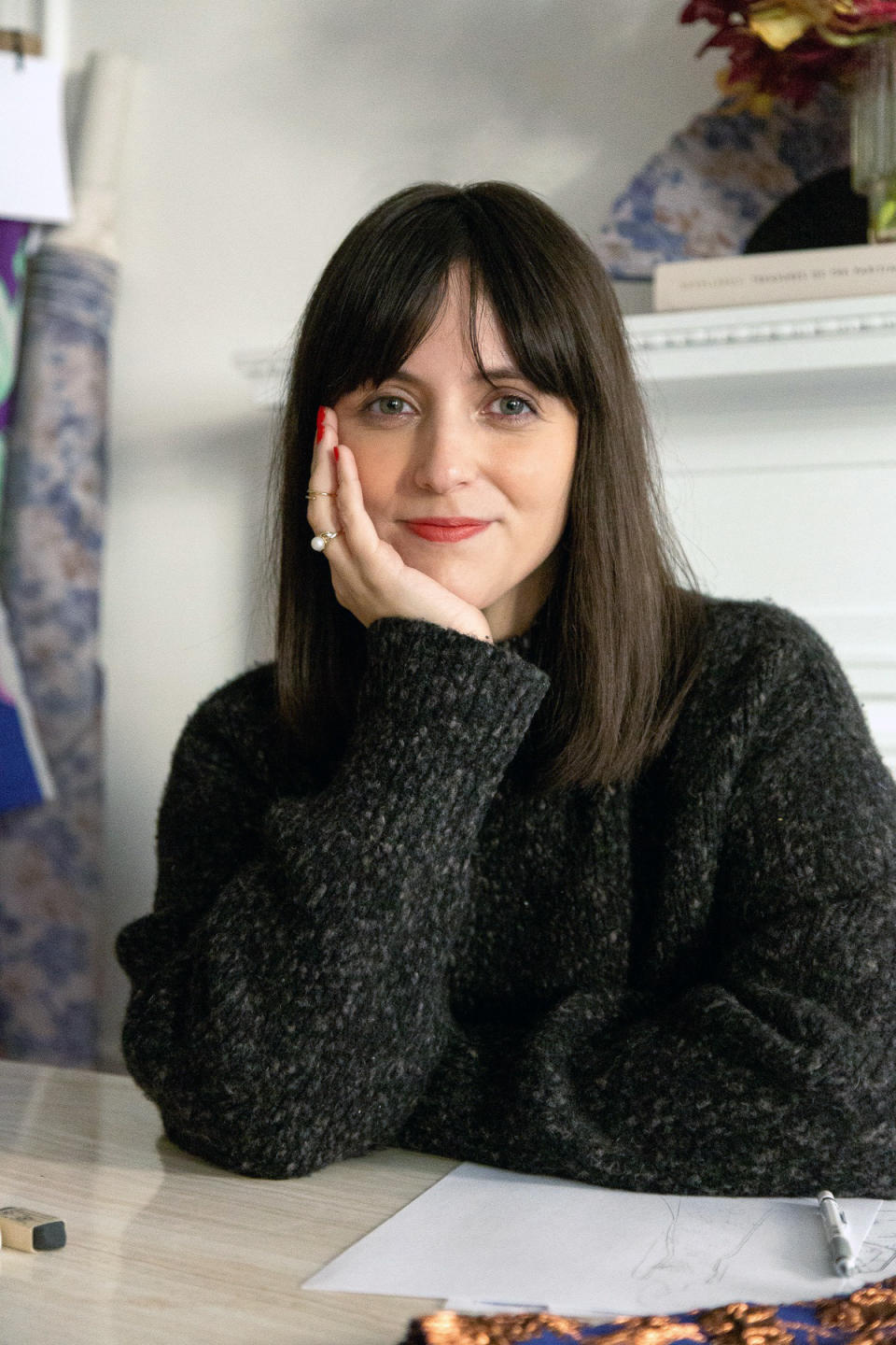 Designer Patricia Voto sits in her Upper East Side studio for a portrait wearing a gray sweater from her label One Of