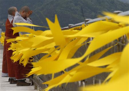 Buddhist nuns cry after praying for the missing and dead passengers onboard the capsized Sewol ferry, as yellow ribbons dedicated to the victims are seen, at a port in Jindo April 26, 2014. REUTERS/Kim Kyung-Hoon