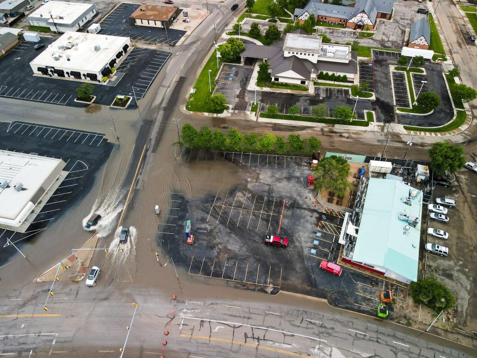 Vehicles try to pass through waterlogged Paramount and Olsen boulevards during flash flooding Friday in Amarillo.