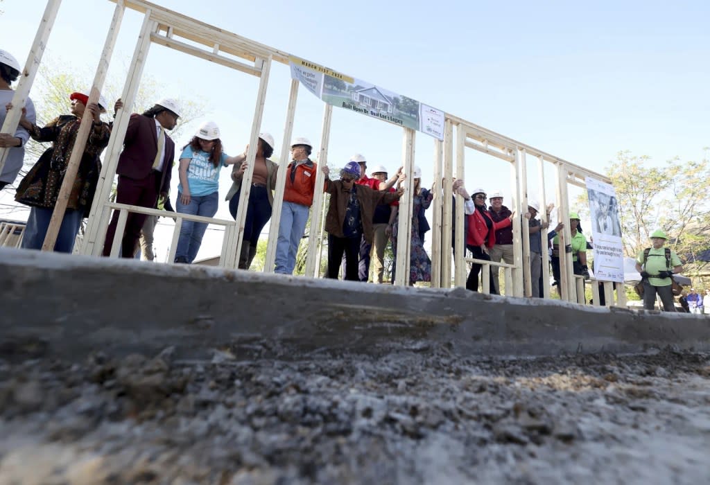 Opal Lee, left, applauds during a ceremony before aising the first wall to her new home on her family’s former lot in Fort Worth, Texas on Thursday, March 21, 2024. (Amanda McCoy /Star-Telegram via AP)