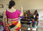 Students wearing face masks as a precaution against the coronavirus listen to their teacher during a class at Maharani College for Women in Bengaluru, India, Tuesday, Nov. 24, 2020. India has more than 9 million cases of coronavirus, second behind the United States. The southern state of Karnataka decided Monday not to reopen schools and pre-university colleges though institutes of higher education were opened last week. (AP Photo/Aijaz Rahi)