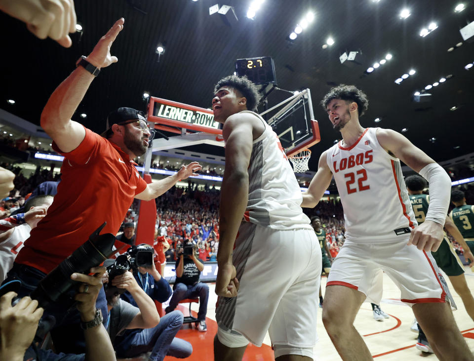 New Mexico guard Donovan Dent, center, celebrates with fans and Mustapha Amzil (22) after scoring the game-winning basket against Colorado State in an NCAA college basketball game, Wednesday, Feb. 21, 2024, in Albuquerque, N.M. (AP Photo/Eric Draper)