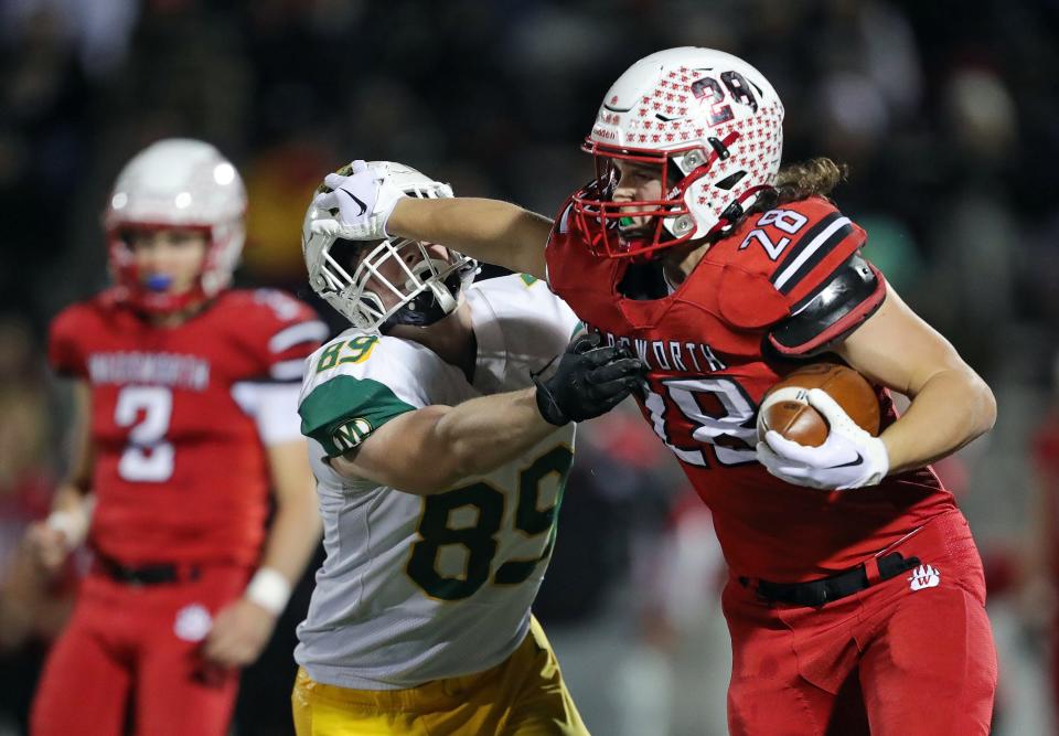 Wadsworth running back Kyle Figuray, right, stiff arms Medina defensive lineman Chad Gatchell Jr. during a Division I regional quarterfinal Friday in Wadsworth.