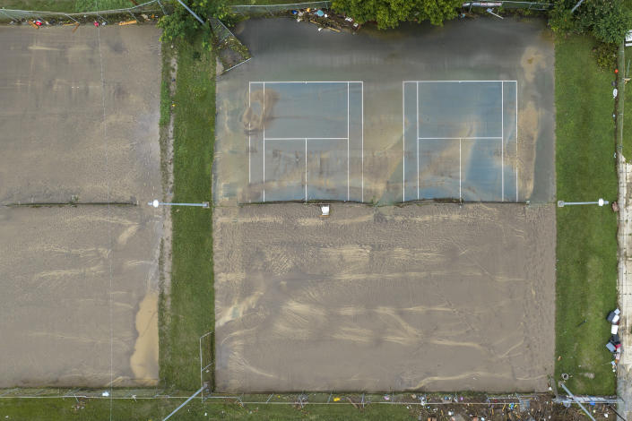 Mud covers tennis courts near Whitesburg Middle School in Whitesburg, Ky., on Friday, July 29, 2022. (Ryan C. Hermens/Lexington Herald-Leader via AP)