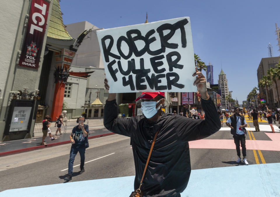 A demonstrator carries a sign reading: "Robert Fuller 4Ever" during an All Black Lives Matter march organized by black members of the LGBTQ community, in the Hollywood section of Los Angeles on Sunday, June 14, 2020. Los Angeles County Sheriff Alex Villanueva will hold an online town hall Monday, June 15, to address the death of a black man found hanging from a tree in the city of Palmdale last week. Robert Fuller's body was discovered last Wednesday at a park near City Hall. The county medical examiner-coroner's office said the 24-year-old appeared to have died by suicide, prompting an outcry by his family who believed he wasn't suicidal and community members who called for an independent investigation and autopsy. (AP Photo/Damian Dovarganes)