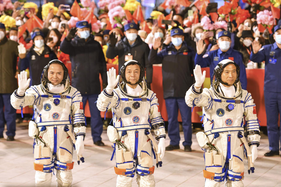In this photo released by Xinhua News Agency, from right, Chinese astronauts Fei Junlong, Deng Qingming and Zhang Lu wave as they attend a send-off ceremony ahead of the Shenzhou-15 manned space mission at the Jiuquan Satellite Launch Center in northwest China on Tuesday, Nov. 29, 2022. China launched the rocket Tuesday carrying three astronauts to complete construction of the country's permanent orbiting space station. (Liu Lei/Xinhua via AP)