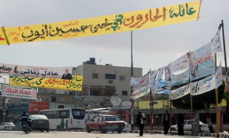 People walk at the square under electoral banners ahead of the second round of parliamentary election, in Al Arish city, North Sinai, Egypt, November 19, 2015. REUTERS/Stringer