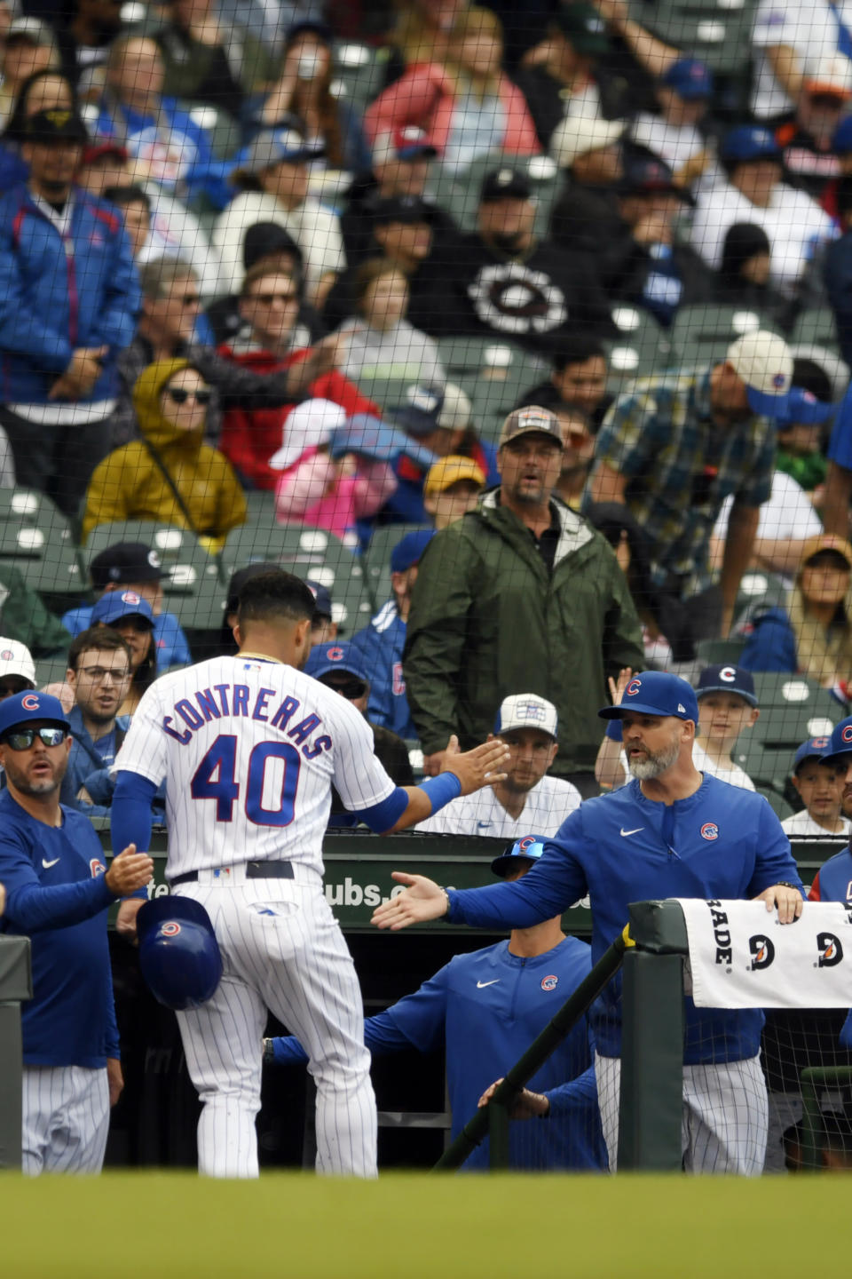 Chicago Cubs' Willson Contreras (40) celebrates with manager David Ross, right, at the dugout after scoring on a single by Frank Schwindel during the first inning of a baseball game against the Pittsburgh Pirates, Sunday, April 24, 2022, in Chicago. (AP Photo/Paul Beaty)