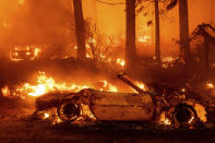 Flames consume vehicles as the Dixie Fire tears through the Indian Falls community in Plumas County, Calif., Saturday, July 24, 2021. The fire destroyed multiple residences in the area. (AP Photo/Noah Berger)