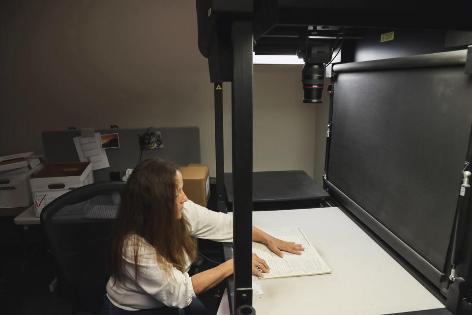 A tracing center worker takes photographs of old gun records that cannot be scanned. (Peter Kavanagh / NBC News)