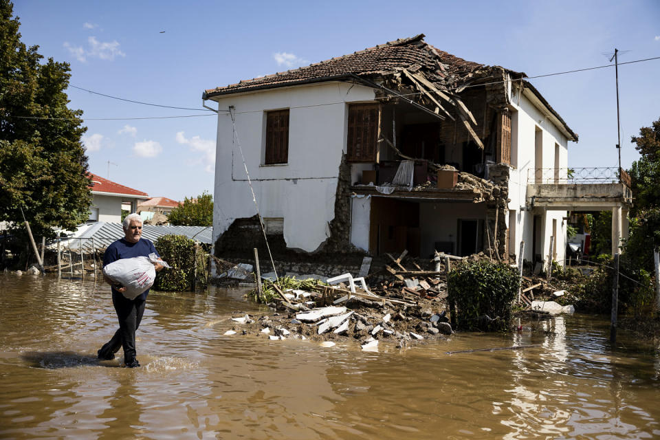 A man walks in front of a destroyed house in the flooded village of Palamas, Greece, on Sept. 8, 2023. (Yorgos Karahalis / dpa/picture alliance via Getty Images file)