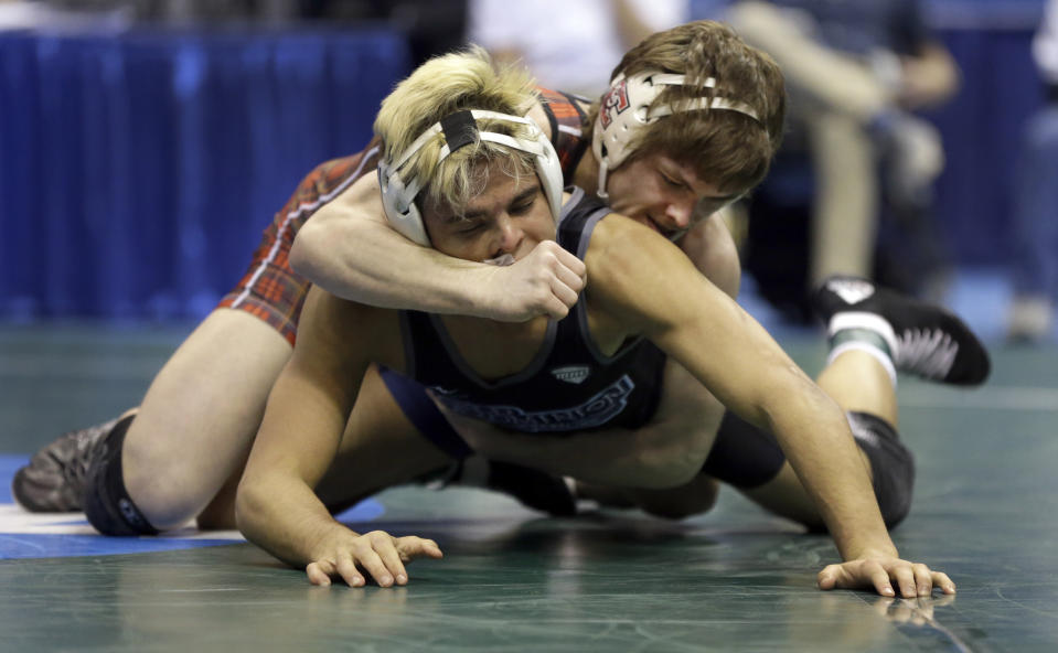 FILE - In this March 20, 2015, file photo, Edinboro's Mitchell Port, right, wrestles Old Dominion's Chris Mecate during their 141-pound semifinal at the NCAA Division I Wrestling Championships in St. Louis. Old Dominion said in early April it would discontinue wrestling, a decision affecting 32 student-athletes and saving about $1 million. Colleges mulling whether to cut sports amid the coronavirus pandemic must ensure they remain compliant with the federal civil-rights law known as Title IX, which requires the equitable treatment of remaining men's and women's programs. (AP Photo/Jeff Roberson, File)