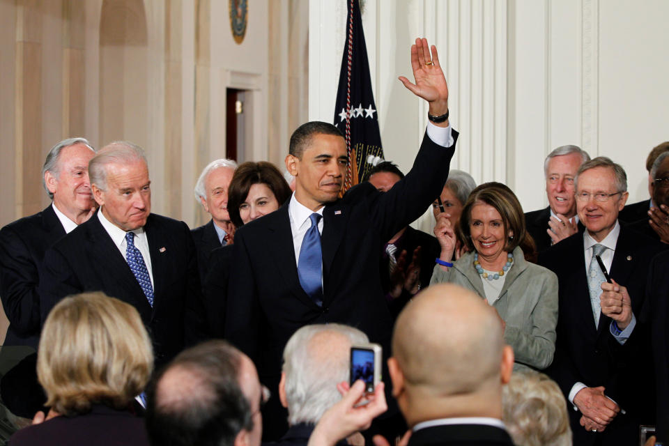 U.S. President Barack Obama waves to the audience after signing the Affordable Care Act, dubbed Obamacare, the comprehensive healthcare reform legislation during a ceremony in the East Room of the White House in Washington, U.S., March 23, 2010. With Obama on stage are Vice President Joe Biden (L), Speaker of the House of Representatives Nancy Pelosi (2nd R) and Senate Majority Leader Harry Reid (R). REUTERS/Jason Reed/File Photo