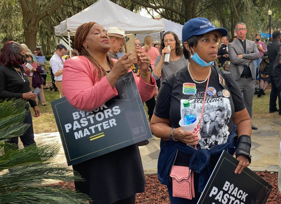 Protesters stand outside the Glynn County Courthouse on Thursday, Nov. 18, 2021 in Brunswick, Ga., during the trial of Greg McMichael and his son, Travis McMichael, and a neighbor, William "Roddie" Bryan. The three are charged with the February 2020 slaying of 25-year-old Ahmaud Arbery. (AP Photo/Jeffrey Collins)