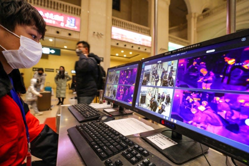 A staff member wearing a mask monitors thermal scanners that detect temperatures of passengers at the security check inside the Hankou Railway Station in Wuhan, Hubei province, China January 21, 2020.  China Daily via REUTERS   