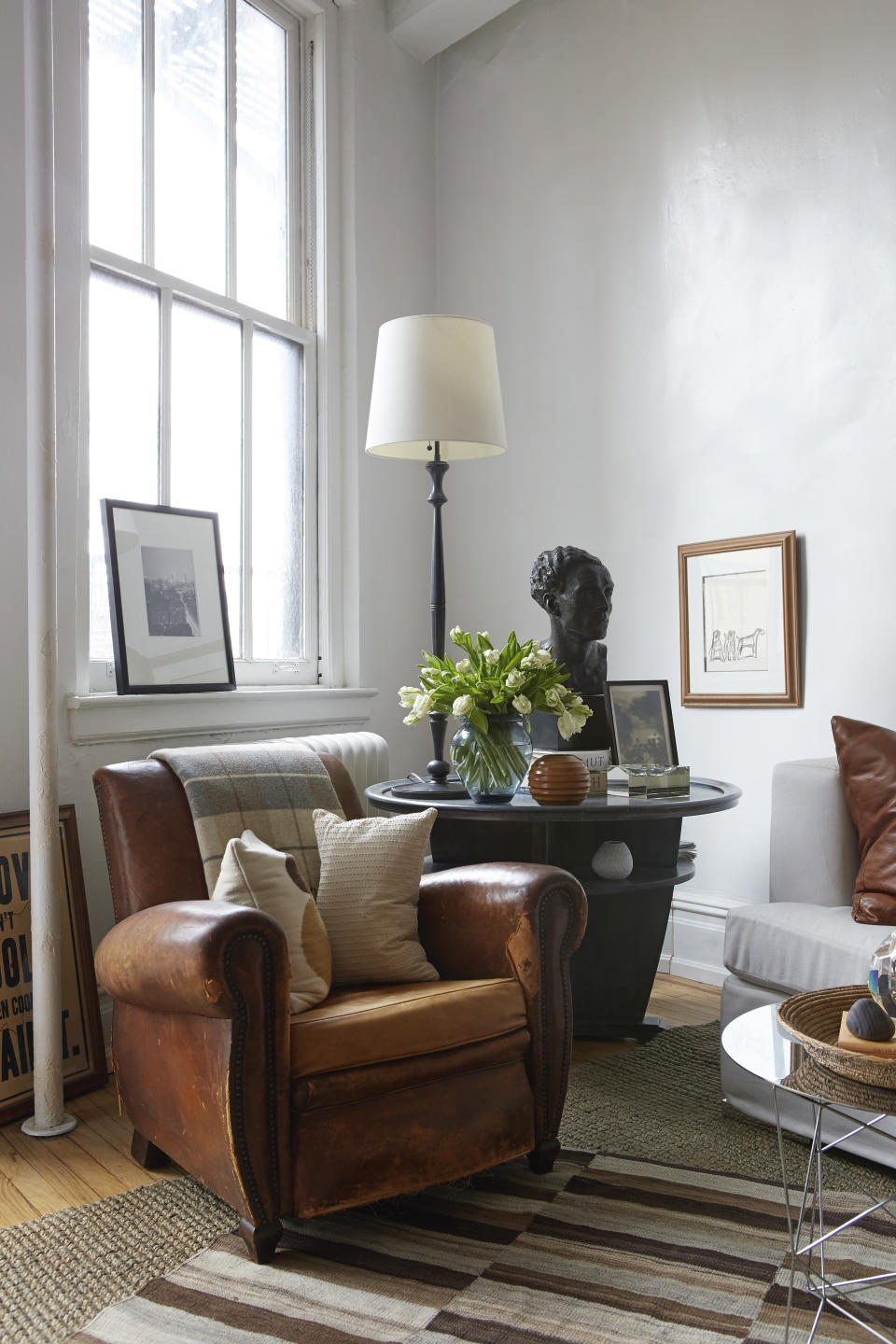 This image provided by BHDM Design shows a leather armchair and a two-tiered table. The designer, Dan Mazzarini, says it's part of a trend toward "slow decorating," which includes an appreciation for high-quality and sustainable vintage pieces, and mixing old and new. (Dan Mazzarini/BHDM Design via AP)