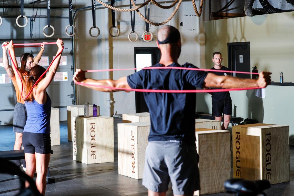 Trainer Wes Parker, right, watches students warm up with stretching exercises before a training session at Full Tilt Gym, 2008 Eastern Parkway near Bardstown Road.