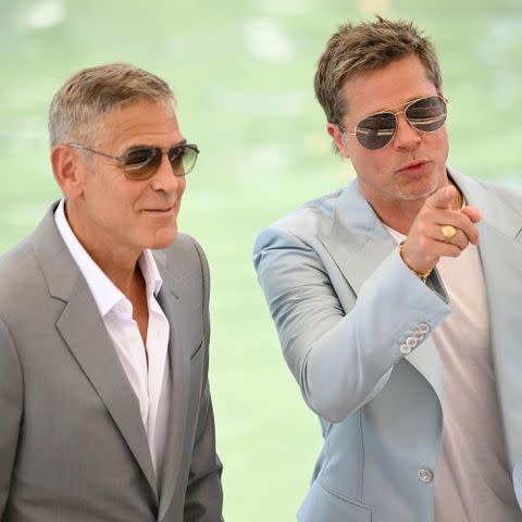 <p>MARCO BERTORELLO/AFP via Getty</p> George Clooney and Brad Pitt