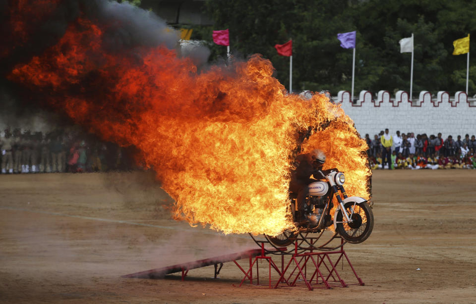 In this Wednesday, Aug. 15, 2018, photo, a member of ASC Tornados, the motorcycle display team of the Indian army, jumps through a fire ring as he performs a daredevil stunt during Indian Independence Day celebrations in Bangalore, India. India won independence from British colonialists in 1947. (AP Photo/Aijaz Rahi, File)