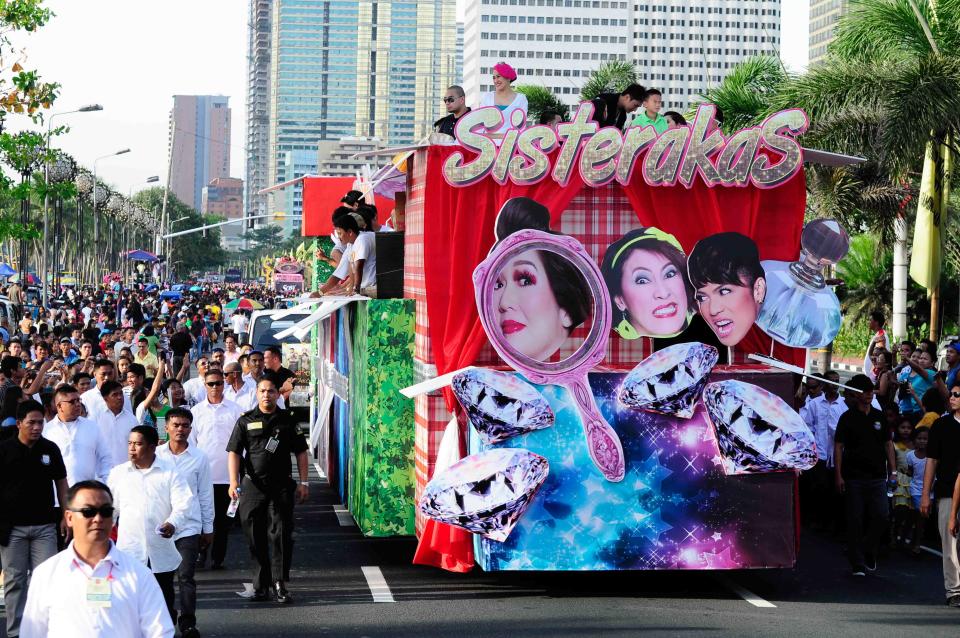 The cast of the MMFF 2012 entry "Sisterekas" waves to the crowd as their float makes its way at the 2012 Metro Manila Film Festival Parade of Stars on 23 December 2012. (Angela Galia/NPPA Images)