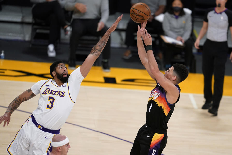 Phoenix Suns guard Devin Booker, right, shoots over Los Angeles Lakers forward Anthony Davis (3) during the first half of an NBA basketball game Sunday, May 9, 2021, in Los Angeles. (AP Photo/Marcio Jose Sanchez)