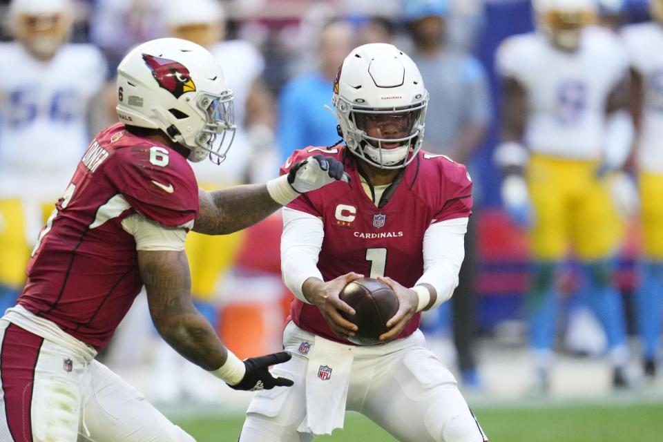 Arizona Cardinals quarterback Kyler Murray hands the ball to running back James Conner.