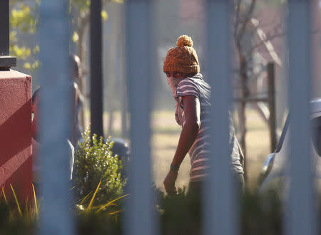 A masked student at the University of the Western Cape flees as police open fire with rubber bullets and teargas during protests demanding free tertiary education in Cape Town, South Africa. REUTERS/Mike Hutchings