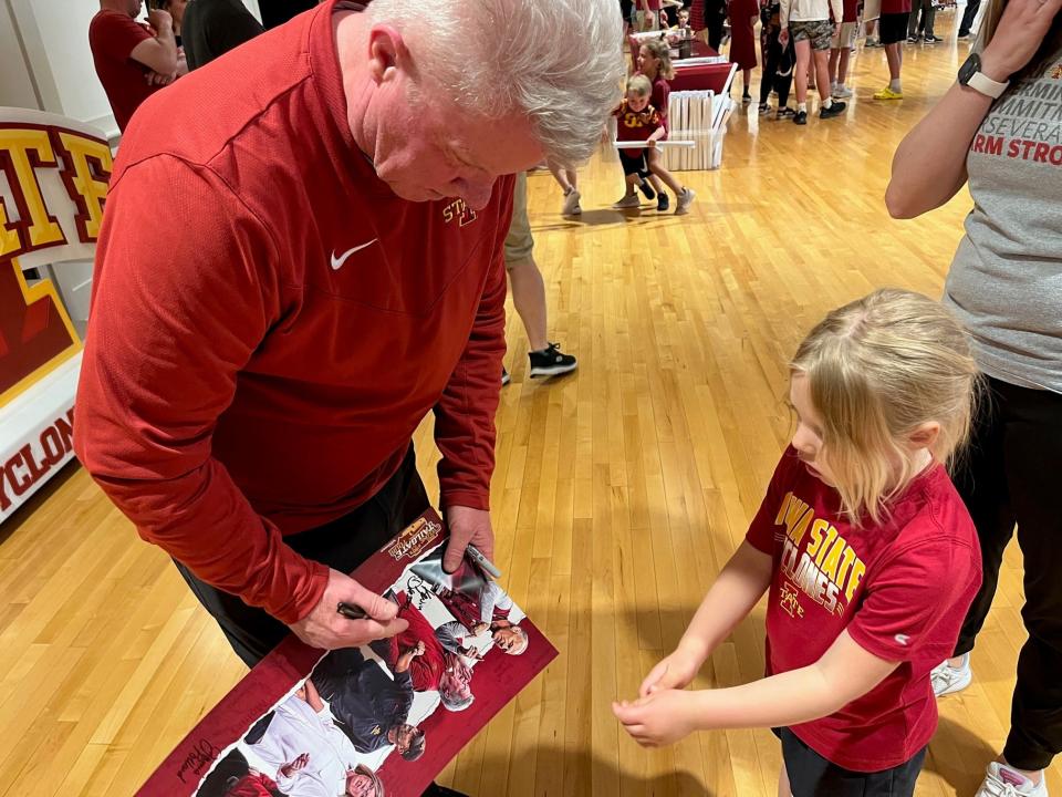 Women's basketball coach Bill Fennelly signs autographs at the Cyclone Tailgate Tour stop in Arnolds Park Tuesday night.