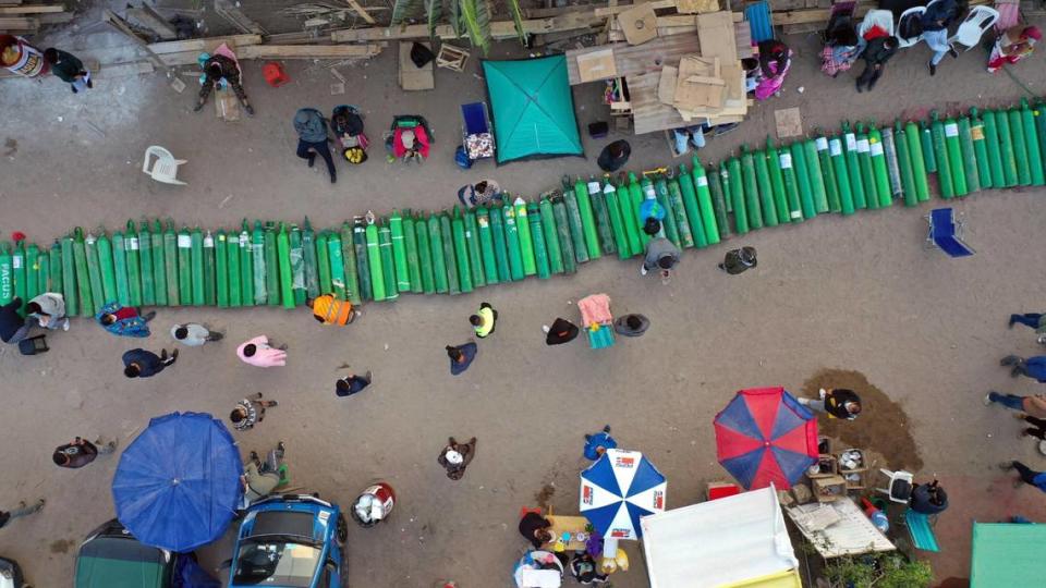 Dozens of empty oxygen cylinders lay across a dirt road, as people wait for a shop to open in order to refill their tanks in the Villa El Salvador neighborhood, as the lack of medical oxygen to treat COVID-19 patients continues in Lima, Peru, Tuesday, April 6, 2021.