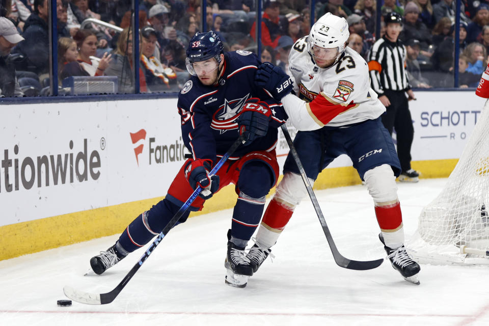 Columbus Blue Jackets defenseman David Jiricek, left, controls the puck in front of Florida Panthers forward Carter Verhaeghe during the second period of an NHL hockey game in Columbus, Ohio, Sunday, Dec. 10, 2023. (AP Photo/Paul Vernon)