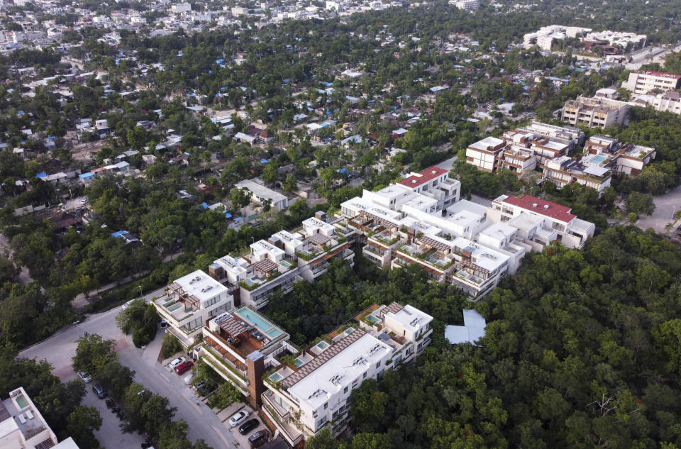 Vista aérea de complejos de modernos departamentos para turistas construidos junto a un barrio pobre surgido en tierras ocupadas de Tulum (México), en foto del 4 de agosto del 2022. (AP Photo/Eduardo Verdugo)