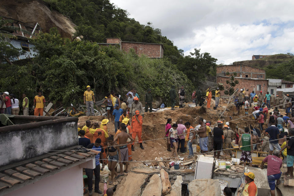 Residents, volunteers and firefighters work over the debris after a mudslide in Boa Esperanca or "Good Hope" shantytown in Niteroi, Brazil, Saturday, Nov. 10, 2018. Several people were killed and others injured in a mudslide near Rio de Janeiro on Saturday, Brazilian authorities said. (AP Photo/Leo Correa)