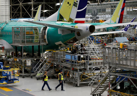 FILE PHOTO: Employees walk by the end of a 737 Max aircraft at the Boeing factory in Renton, Washington, U.S., March 27, 2019. REUTERS/Lindsey Wasson/File Photo