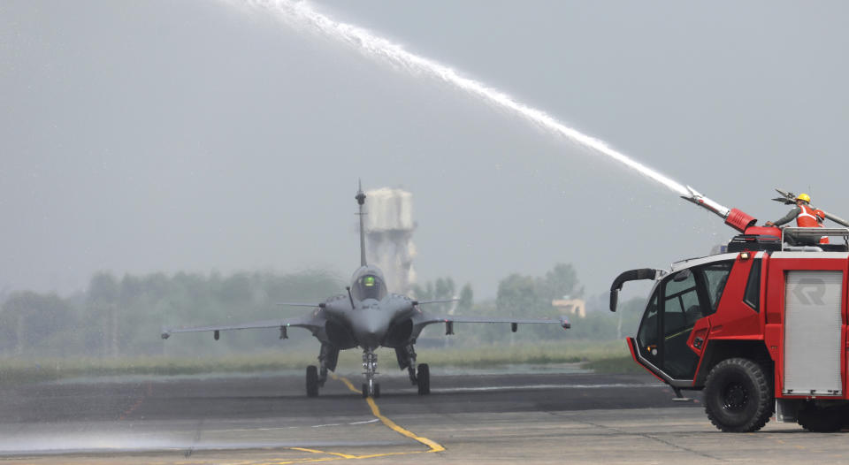 Water is sprayed on a French-made Rafale fighter jet during its induction ceremony at the Indian Air Force Station in Ambala, India, Thursday, Sept.10, 2020. The first batch of five planes, part of a $8.78 billion deal signed between the two countries in 2016 had arrived here in July. (AP Photo/Manish Swarup)