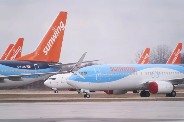 Boeing 737s belonging to Canadian Vacation air carrier Sunwing sit on the tarmac at Waterloo International Airport in Waterloo, Ontario on March 24, 2020.