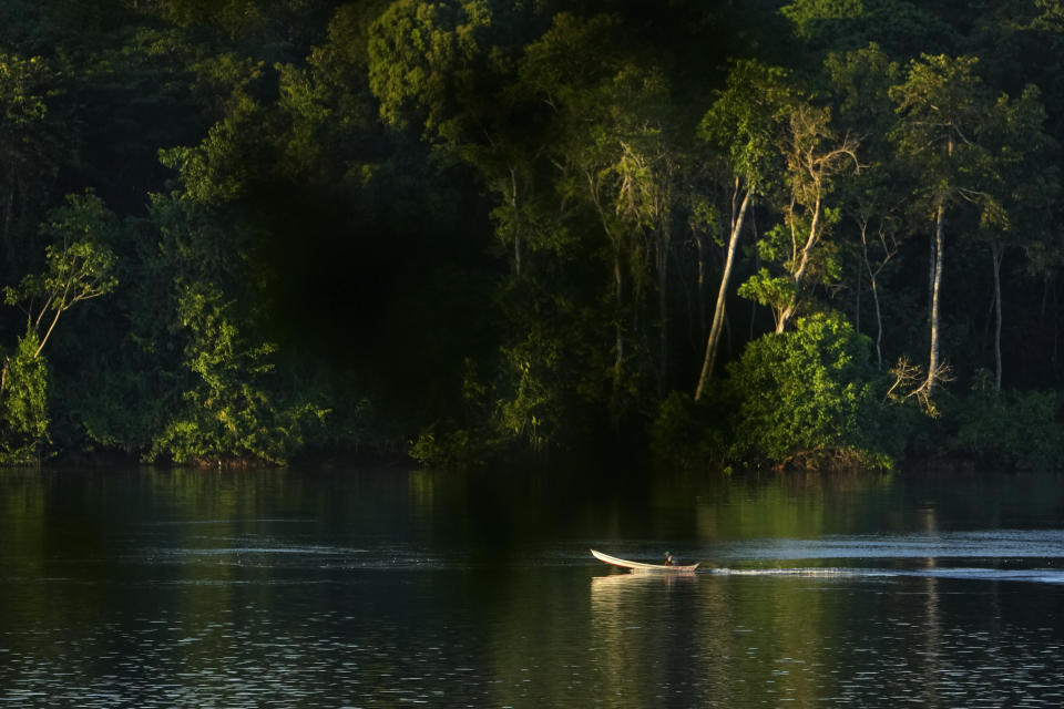 A man navigates his boat in the Tocantis River, in the city of Mocajuba, Para state, Brazil, at dawn Friday, June 2, 2023. (AP Photo/Eraldo Peres)