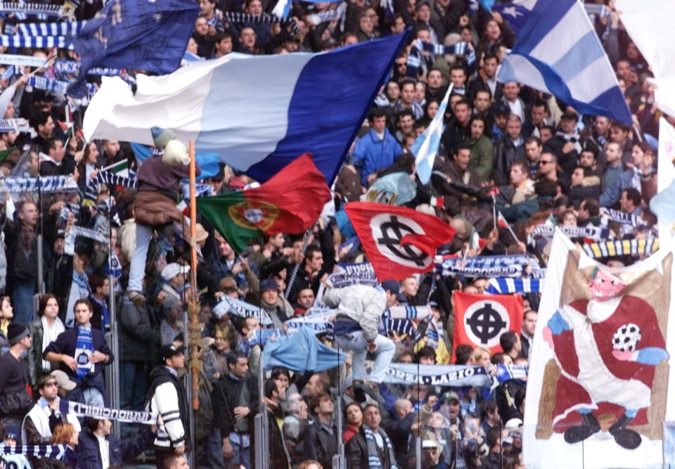 Lazio Rome&#39;s fans, with neo-nazi&#39;s flags, celebrate the entrance of their players,  21 November 1999, during the derby AS Roma-Lazio Roma at the Olympic Stadium. AS Roma beat Lazio 4 goals to 1.   Lazio will play against Omymique de Marseille in Champion&#39;s league, 24 November 1999.   (ELECTRONIC IMAGE) (Photo by Gabriel BOUYS / AFP) (Photo by GABRIEL BOUYS/AFP via Getty Images)