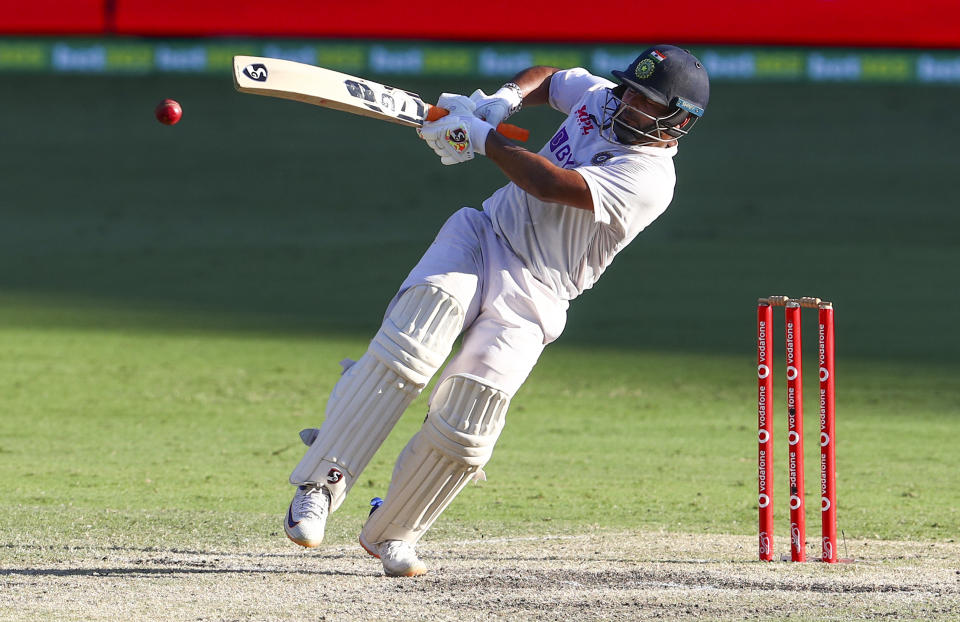 India's Rishabh Pant falls as he hits the ball for four runs during play on the final day of the fourth cricket test between India and Australia at the Gabba, Brisbane, Australia, Tuesday, Jan. 19, 2021. (AP Photo/Tertius Pickard)