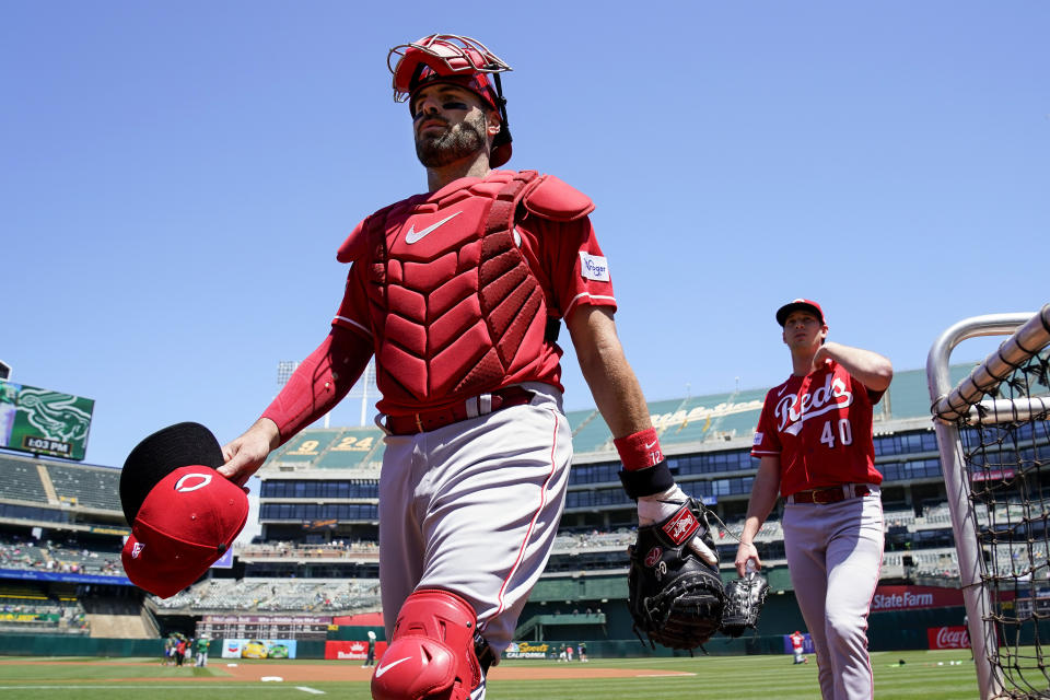 FILE - Cincinnati Reds catcher Curt Casali, left, and pitcher Nick Lodolo, right, walk to the dugout before the team's baseball game against the Oakland Athletics in Oakland, Calif., April 30, 2023. The San Francisco Giants signed Casali to a one-year contract Wednesday, May 15, 2024, amid a growing number of injuries on their roster. Starting catcher Patrick Bailey went back on the seven-day concussion injured list Tuesday after being activated three days earlier, and backup Tom Murphy was transferred to the 60-day IL on Wednesday with a sprained left knee. (AP Photo/Godofredo A. Vásquez, File)