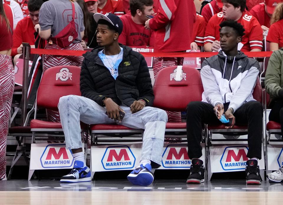 Ohio State basketball commit Felix Okpara, left, and 2023 recruit Scotty Middleton watch the Buckeyes warm up prior to the NCAA men's basketball game against the Michigan Wolverines at Value City Arena in Columbus on March 6, 2022. 