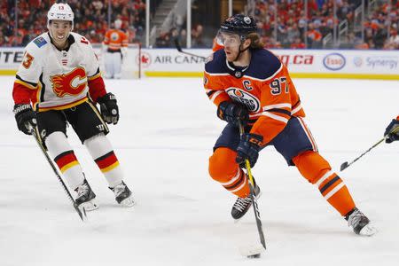 Jan 19, 2019; Edmonton, Alberta, CAN; Edmonton Oilers forward Connor McDavid (97) looks to make a pass in front of Calgary Flames forward Johnny Gaudreau (13) during the first period at Rogers Place. Mandatory Credit: Perry Nelson-USA TODAY Sports