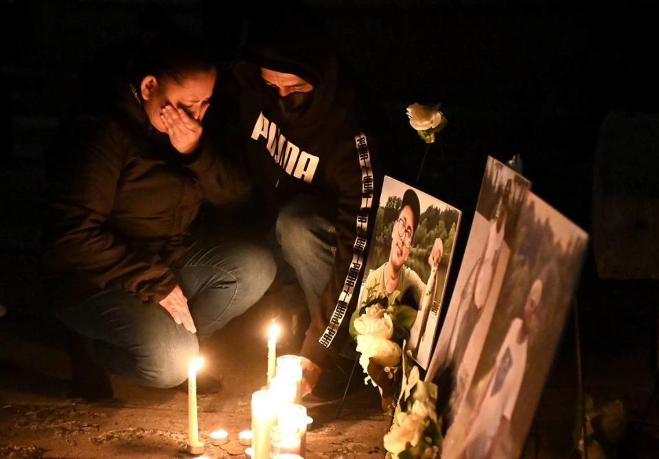 Iris Bonilla, left, and Osman Reyes, right, kneel at a memorial for their son, Jose Canaca, and two other men who were killed in early January 2023 when scaffolding collapsed at a construction site where they were working. The men fell 70 feet (22 meters) when the scaffolding collapsed. Family and friends gathered at Marshall Park on Friday, Feb. 3, 2023, for a candlelight vigil in memory of the three men.