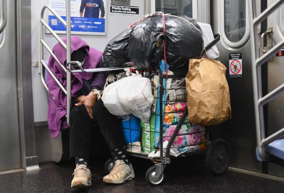 A homeless person sleeps in a subway train in New York City (AFP via Getty Images)