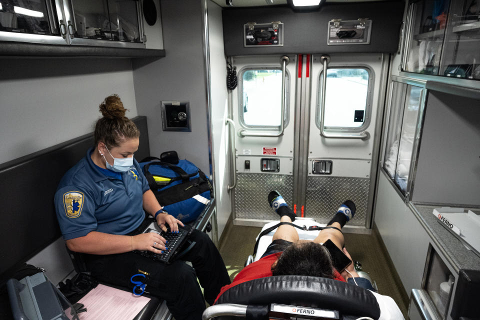 LOUISVILLE, KY - SEPTEMBER 13: A patient experiencing a COVID-19 emergency rides in an ambulance en route to Norton Hospital with a member of Louisville Metro Emergency Medical Services on September 13, 2021 in Louisville, Kentucky. Louisville Metro EMS is experiencing increasing numbers of patients with severe COVID-19 symptoms that require emergency transport to medical facilities. Kentucky Gov. Andy Beshear recently announced that the state surpassed 8,000 total COVID-19 related deaths. (Photo by Jon Cherry/Getty Images)