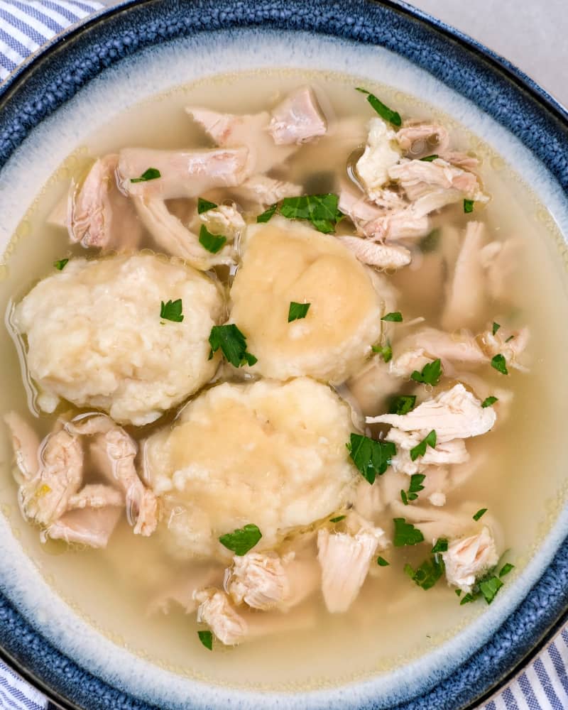 Chicken and dumpling soup in a blue rimmed bowl