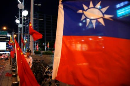 FILE PHOTO: A pro-China supporter adjusts a China national flag during a rally calling for peaceful reunification, days before  the inauguration ceremony of President-elect Tsai Ing-wen, in Taipei, Taiwan May 14, 2016. REUTERS/Tyrone Siu