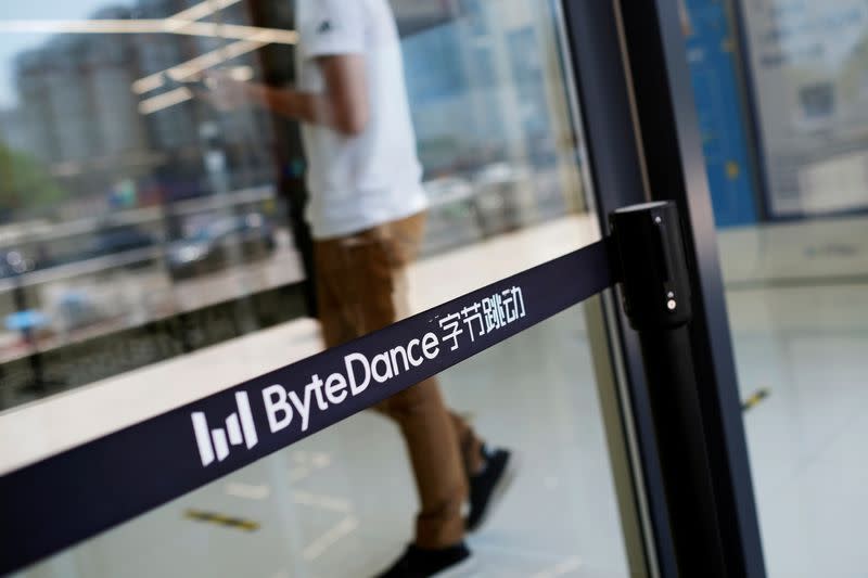 FILE PHOTO: Man walks by a logo of ByteDance, which owns short video app TikTok, at its offices in Beijing