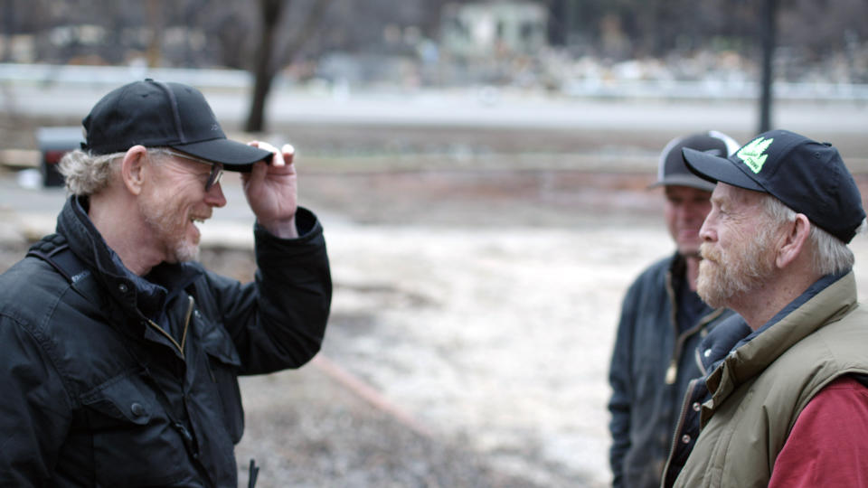 This image released by National Geographic shows filmmaker Ron Howard, left, with Steve "Woody" Culleton during the filming of the documentary "Rebuilding Paradise" in Paradise, Calif. A new documentary by director Ron Howard captures a town's tough recovery following one of the most devastating wildfires in California's history.(Lincoln Else/National Geographic via AP)